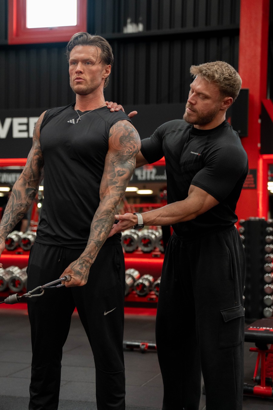 Gary correcting a client's position during a cable exercise